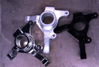 Three cast parts of different finish on a dirty background, seen by a 2D camera